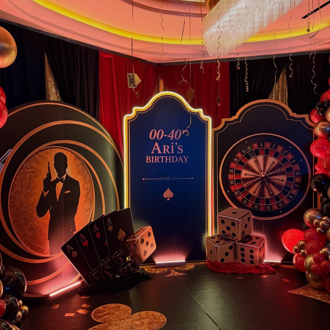 Casino themed birthday decor with roulette wheel, giant dice, and birthday signage.