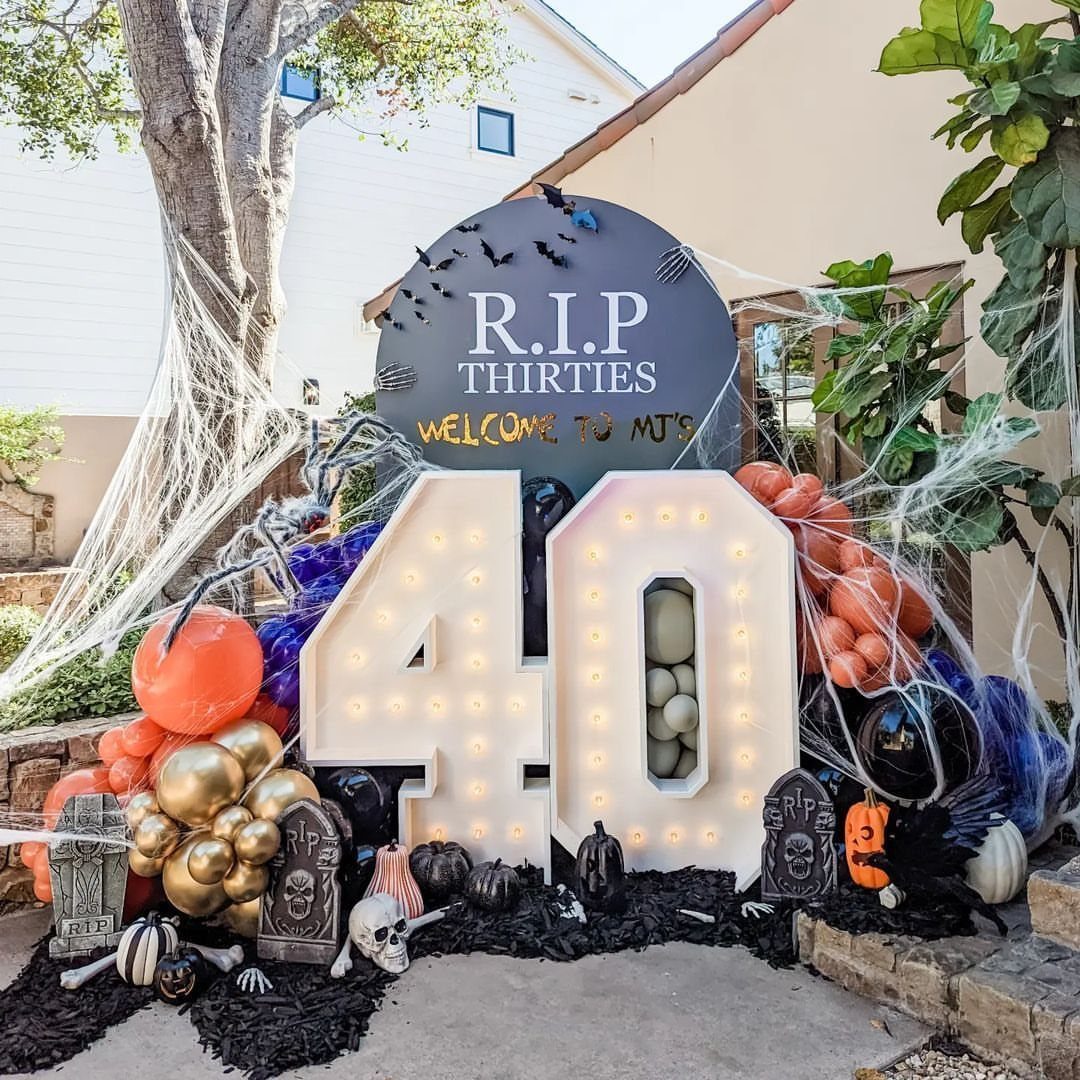 Large illuminated number 40 marquee lights with RIP Thirties sign and Halloween decor.