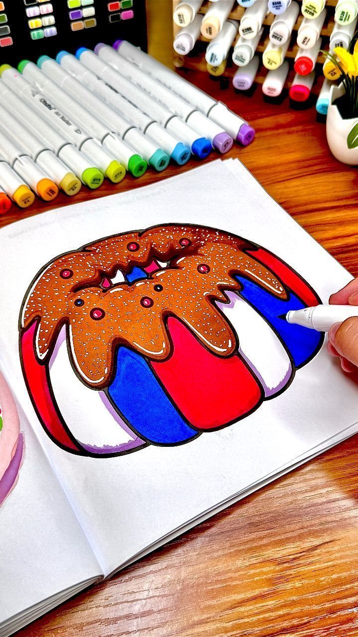 Hand coloring a red, white, and blue patriotic cake with brown frosting.