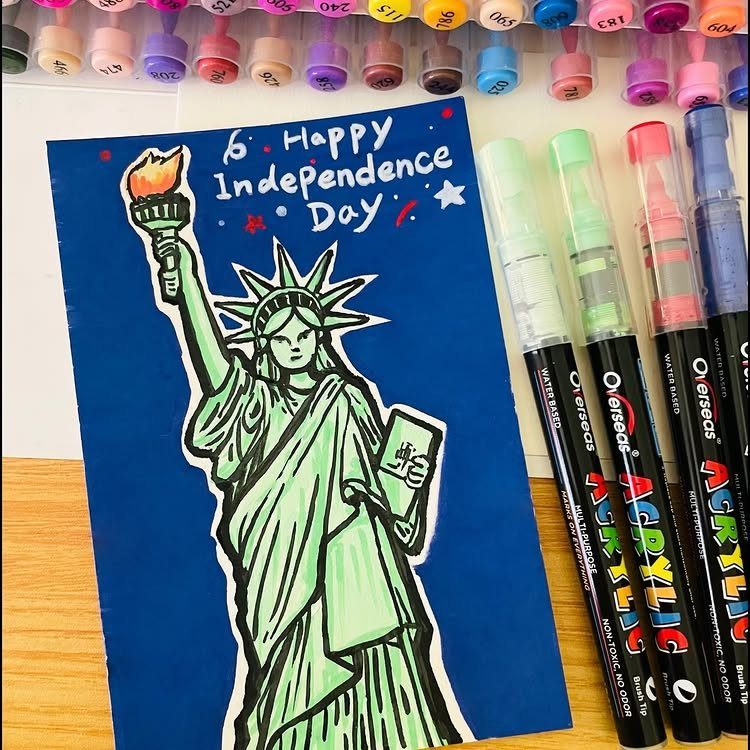 Statue of Liberty drawing on blue paper with acrylic markers and ink pads.