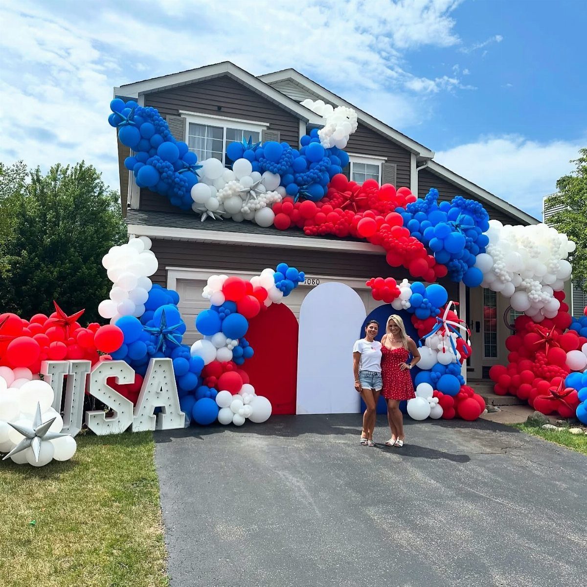 House decorated with red, white, and blue balloons and USA letters for July 4th.