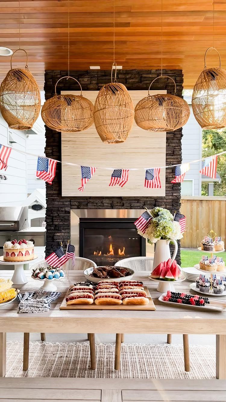 Patriotic table setting with red white and blue treats under American flag bunting.