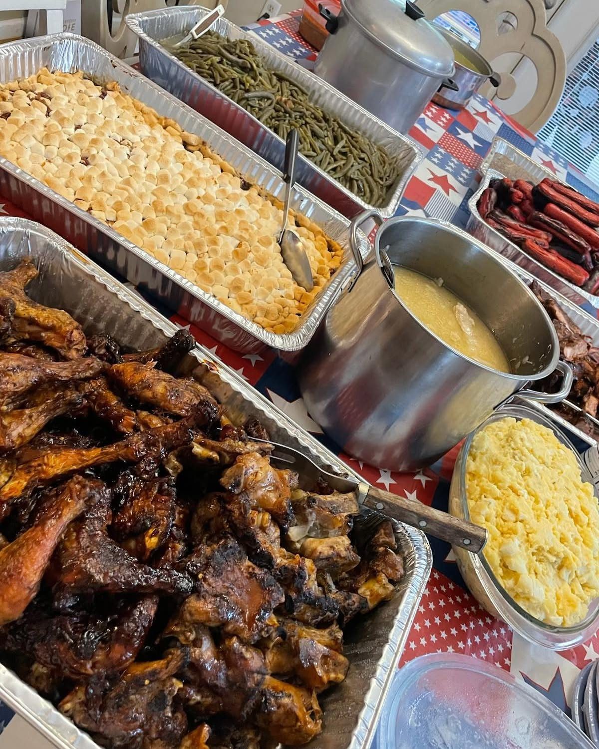 Buffet of ribs and sides on a patriotic star-patterned tablecloth.