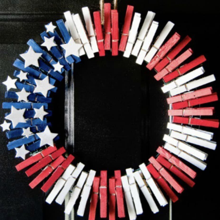 Patriotic wreath made of red, white, and blue painted clothespins on a door