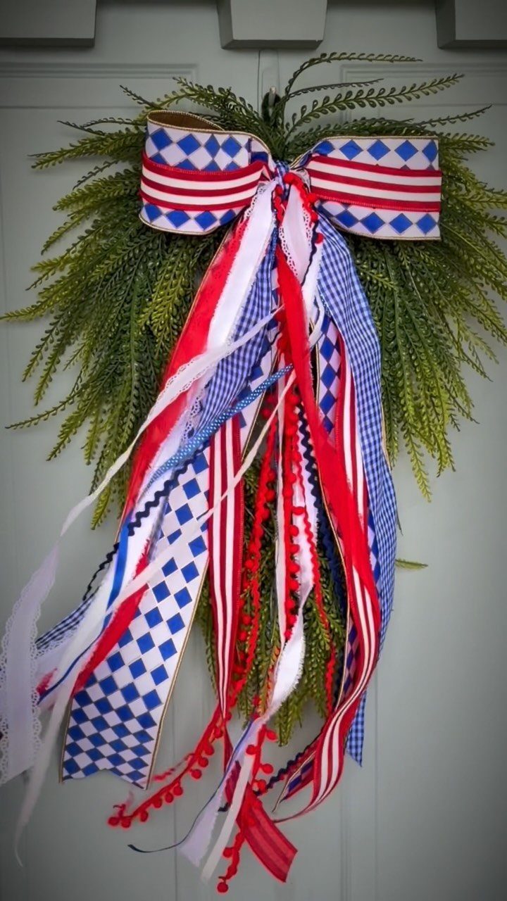 Patriotic red, white, and blue ribbon bow on a green evergreen wreath