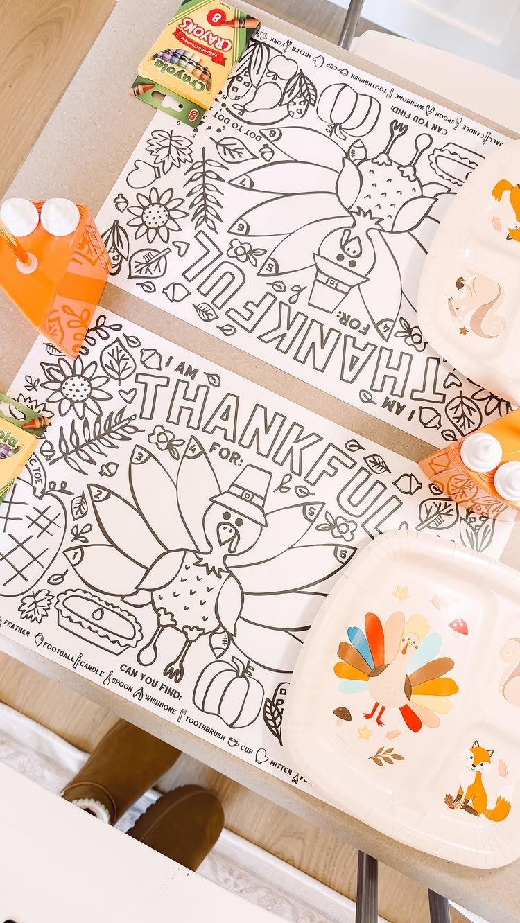 Kids' Thanksgiving table setup with turkey coloring placemats, divided plates, and crayons.