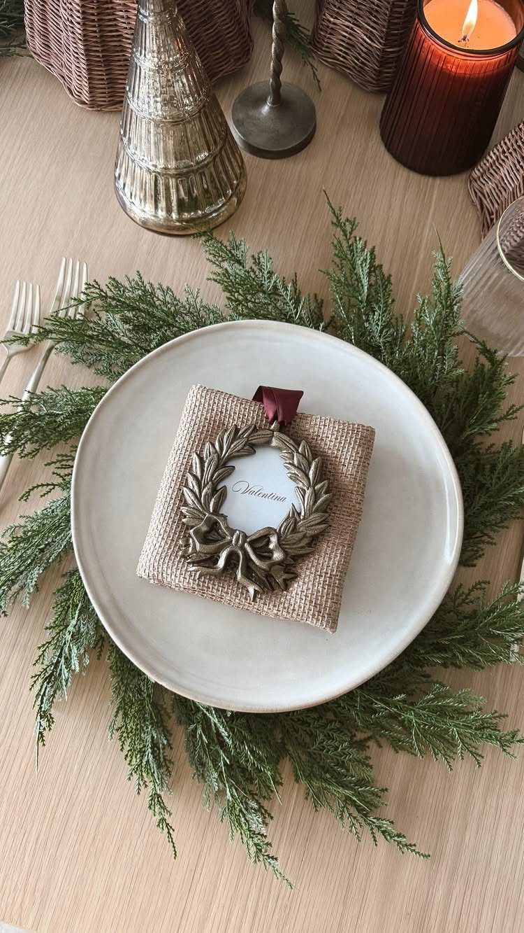 White plate with cedar greenery and a burlap favor featuring a name card.