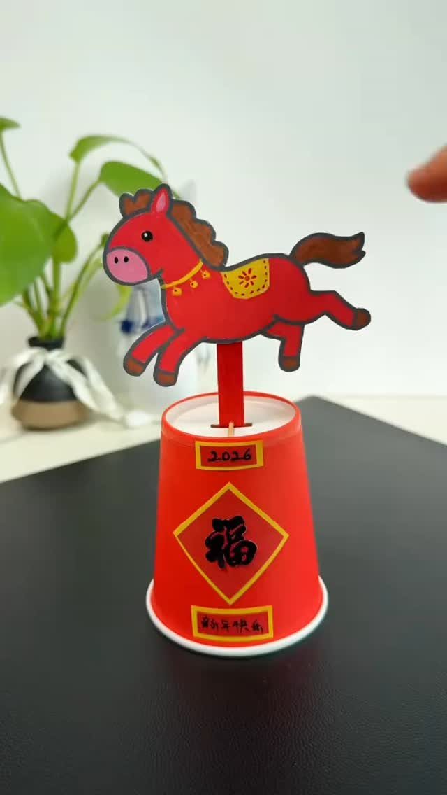 Red paper horse craft on a decorated red cup for Chinese New Year.