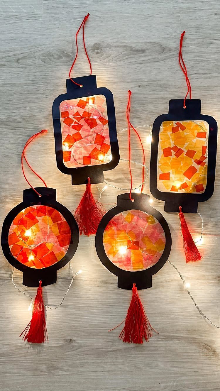 Handmade Chinese lanterns with red and orange tissue paper on a wooden background
