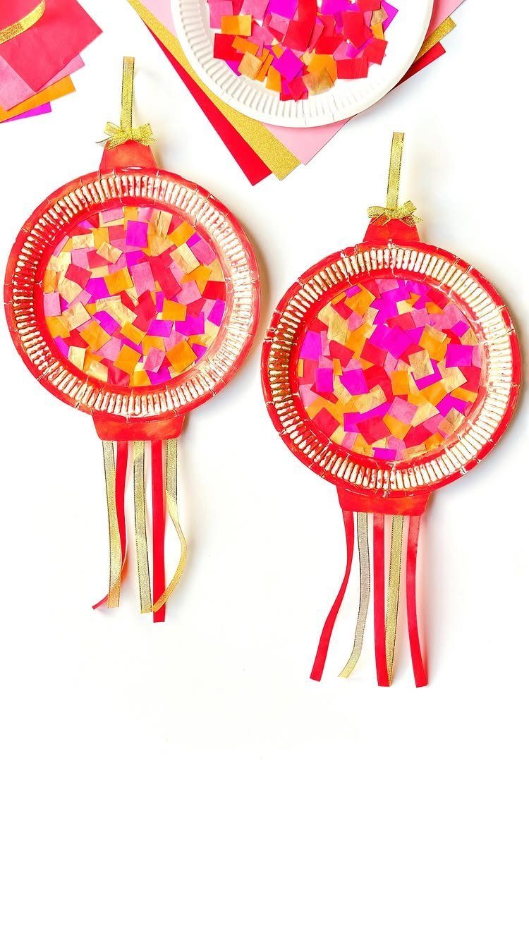 Two red circular paper ornaments with colorful mosaic centers and hanging red tassels.