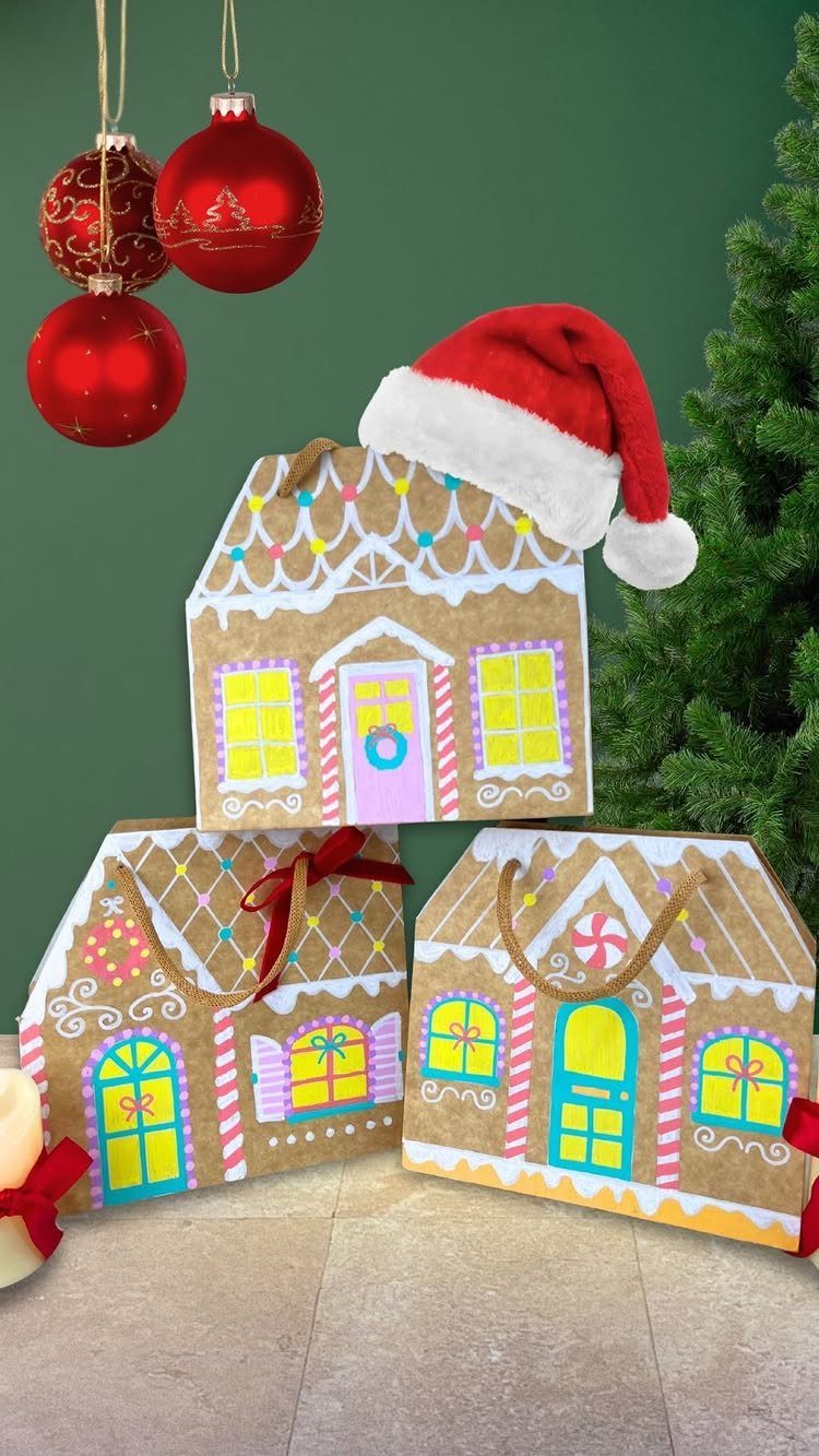 Gingerbread house shaped paper gift bags decorated with colorful icing and holiday ornaments.