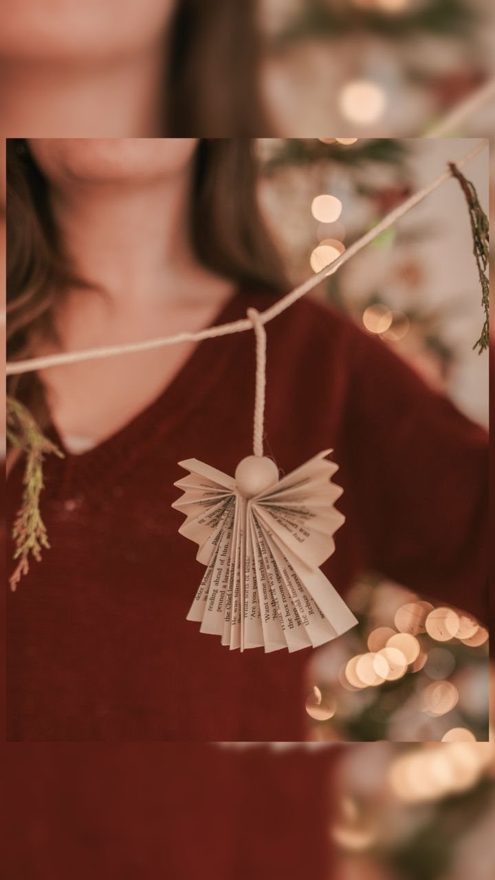 Paper angel ornament made from book pages hanging from a twine string