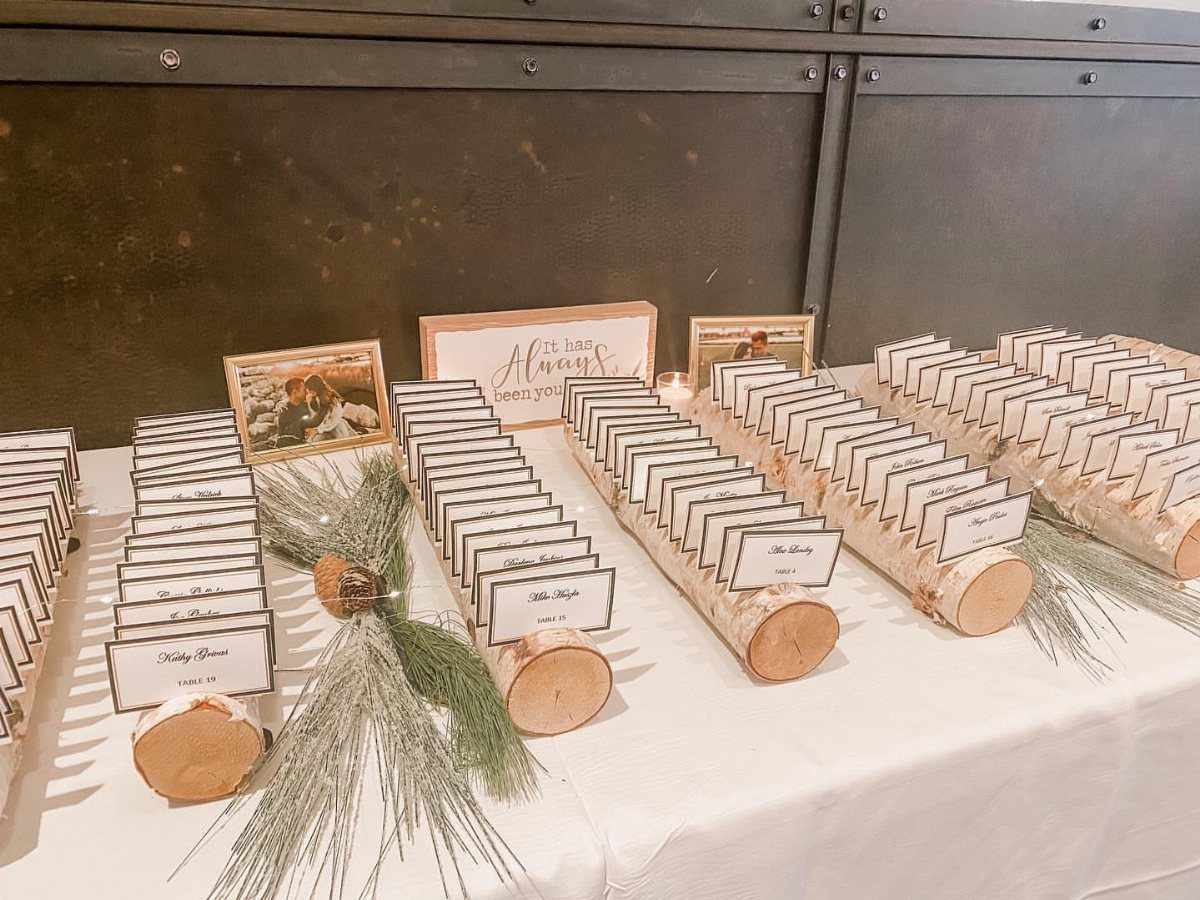 Wooden log slice place card holders with name cards on a white table