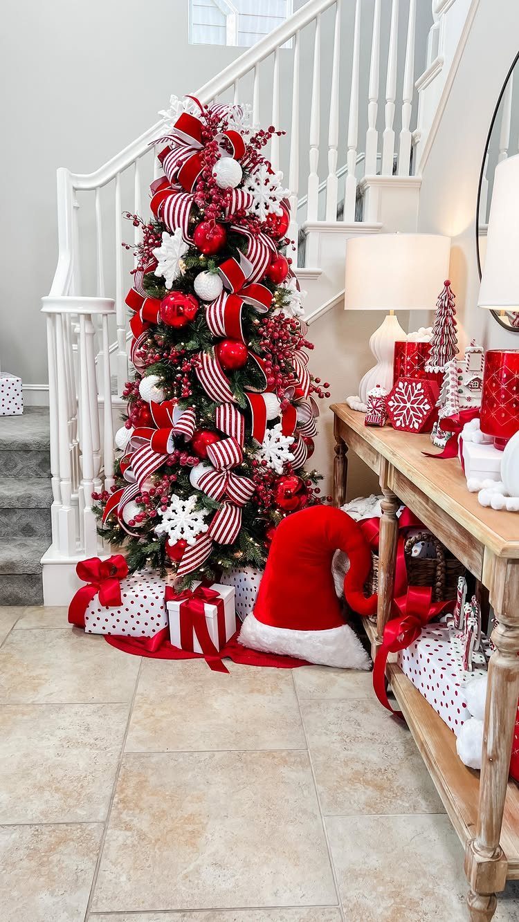 Christmas tree decorated with red and white striped ribbons and red ornaments.