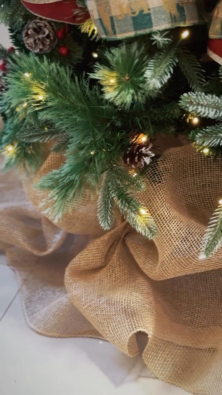 Burlap tree skirt draped around the base of a decorated Christmas tree.