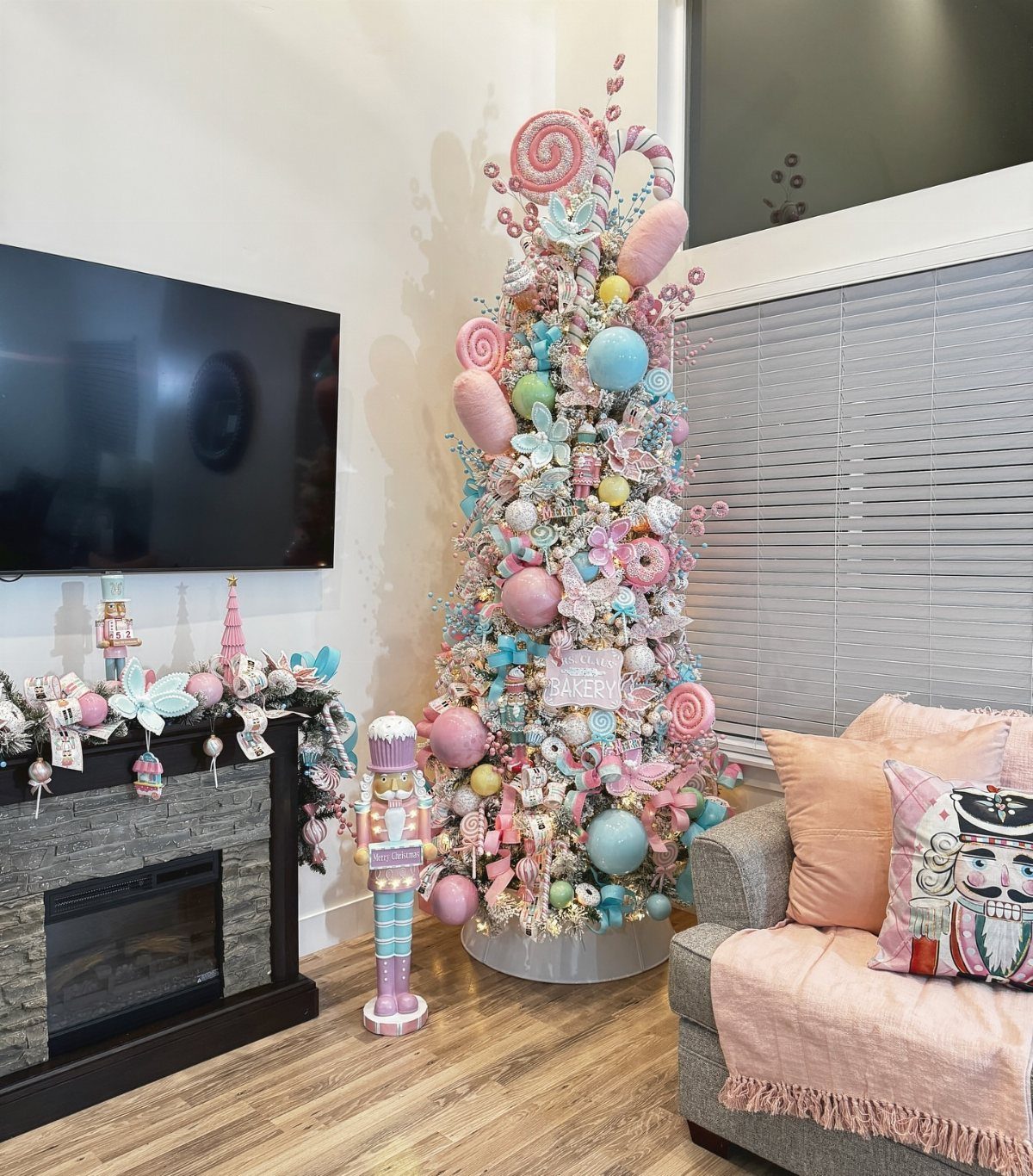 White Christmas tree decorated with pastel pink and blue ornaments and candy swirls.