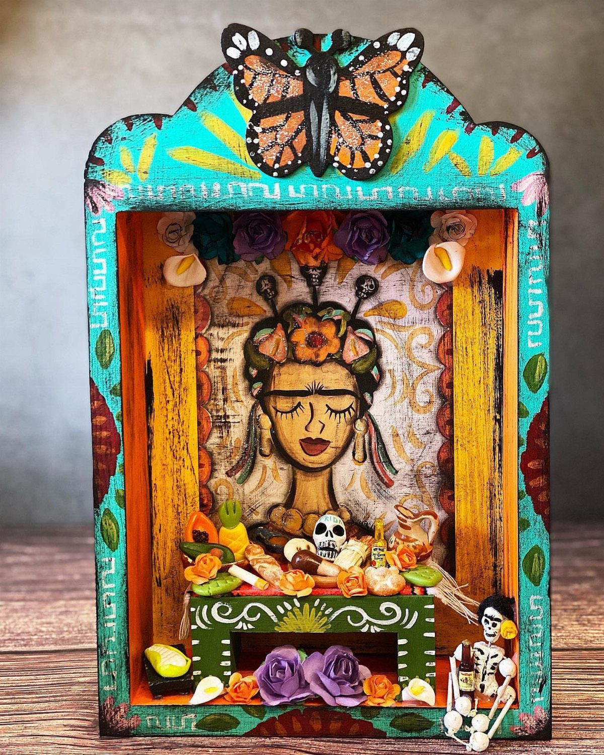 Handcrafted wooden nicho shadow box featuring a woman's portrait and miniature offerings.