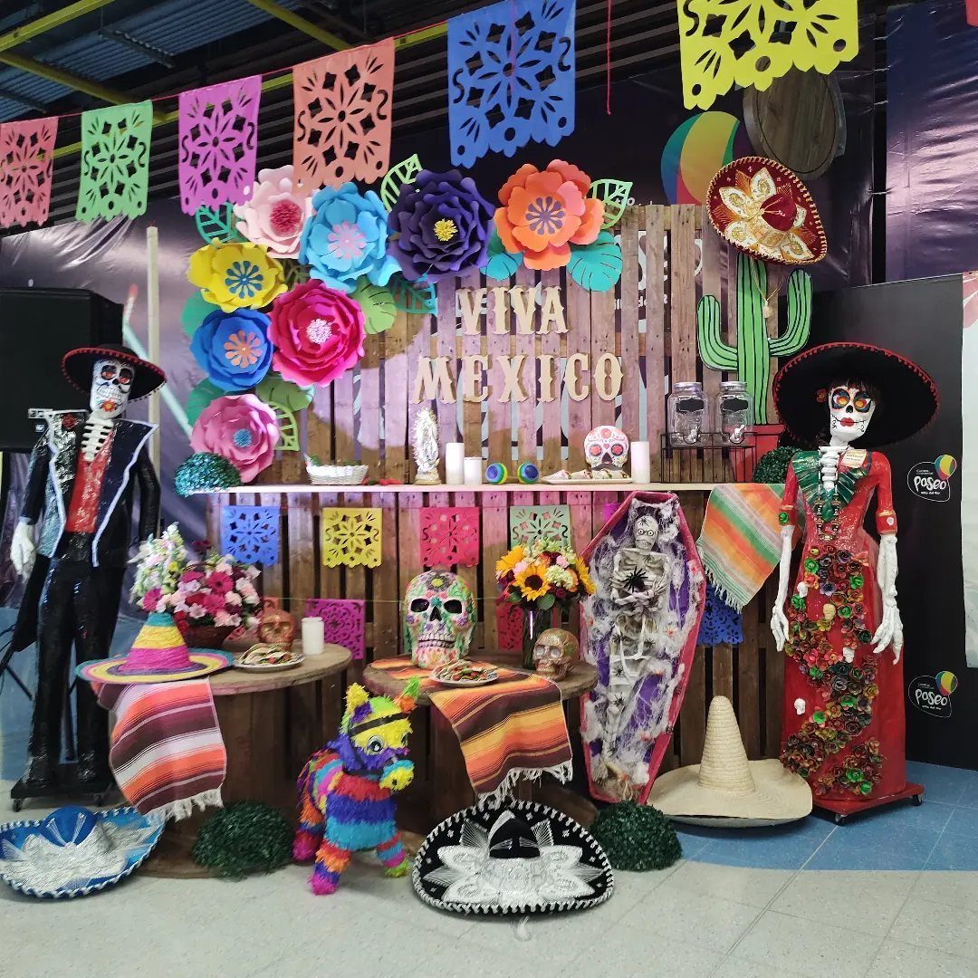 Day of the Dead display with skeleton figures, colorful banners, and sugar skulls.