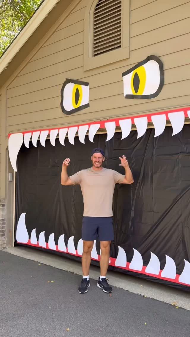 Man posing in front of a garage decorated as a giant monster mouth