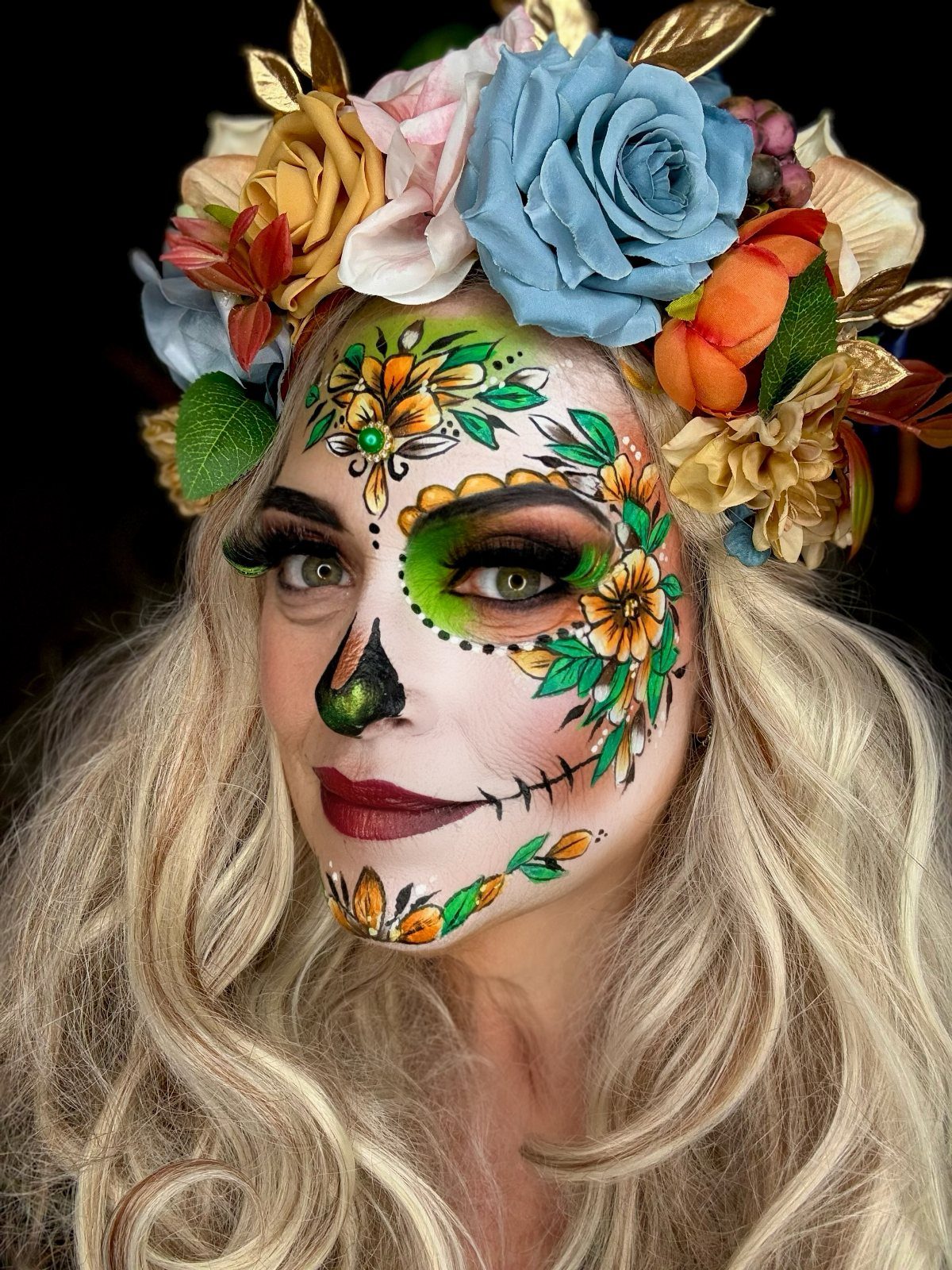 Woman with sugar skull face paint wearing a colorful floral crown