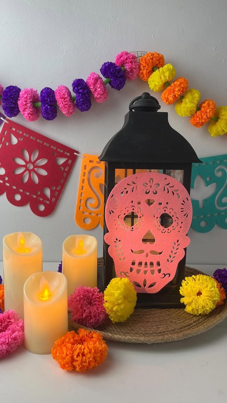 Tissue paper marigolds and a sugar skull lantern on a festive altar setup.