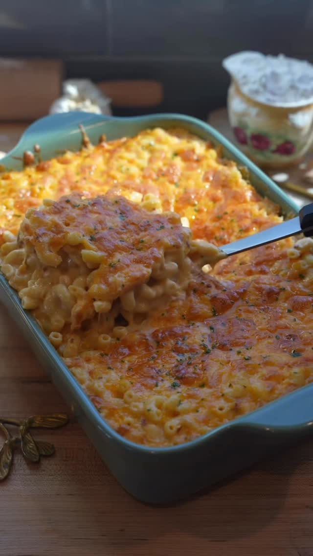 Baked macaroni and cheese in a teal pan with a golden brown crust.