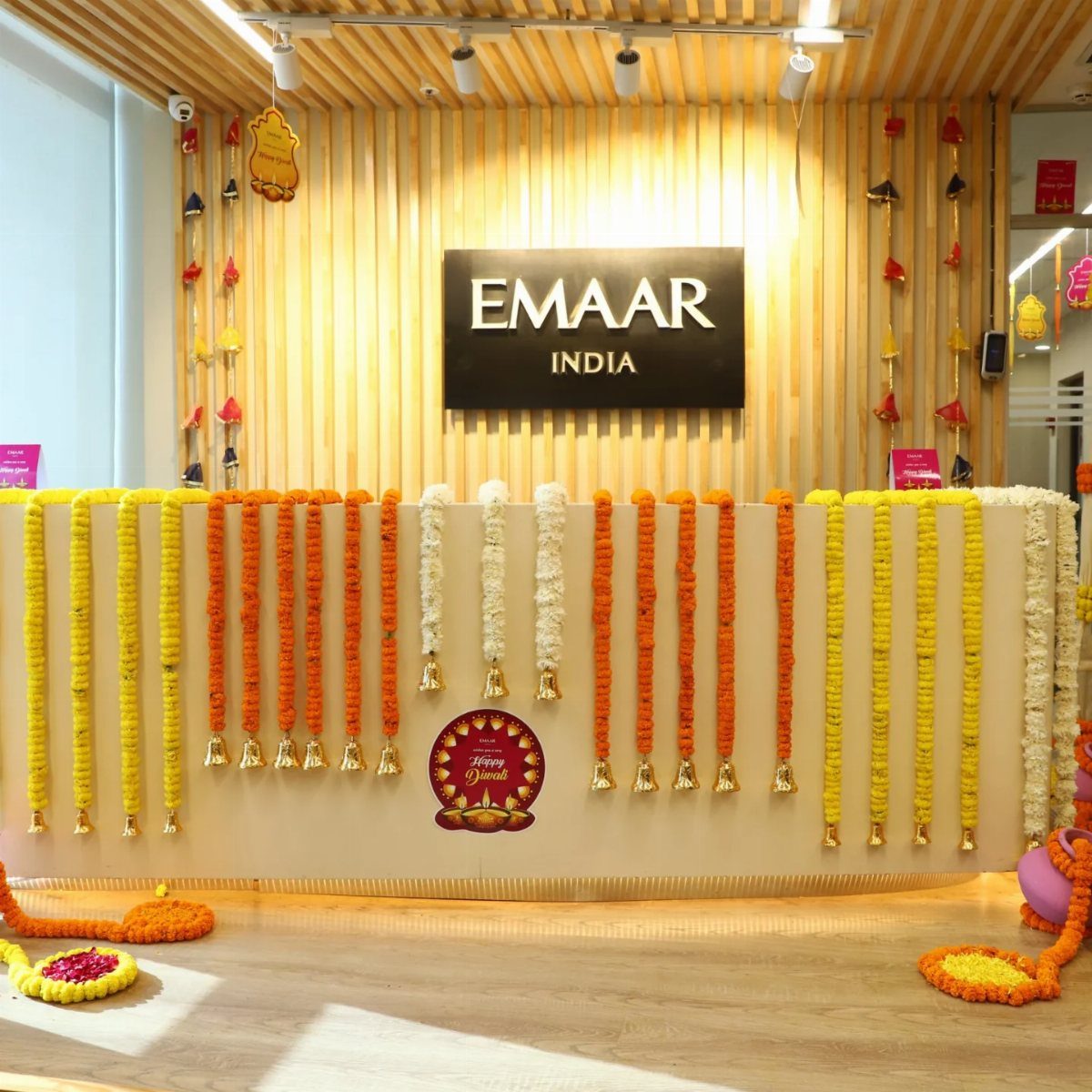 Office reception desk decorated with marigold garlands and floral rangoli for Diwali celebrations.
