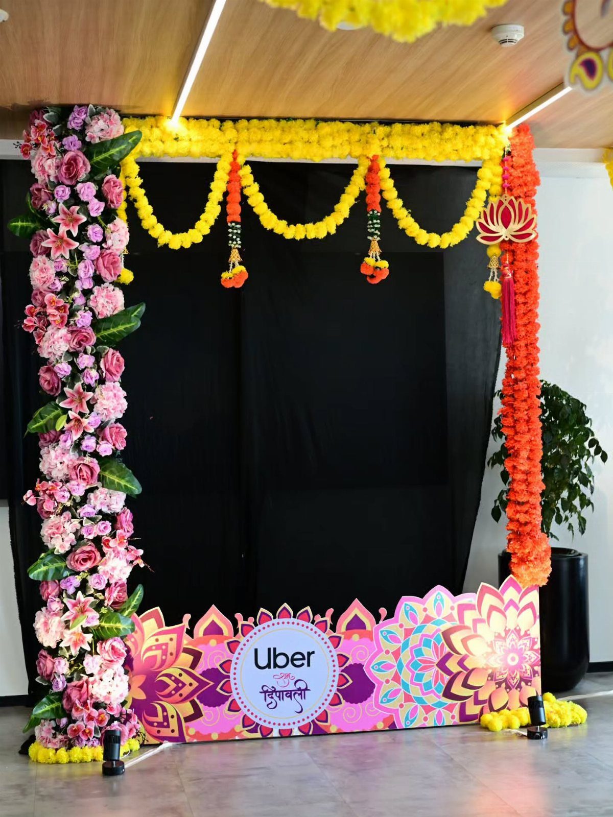Floral photo booth frame with yellow marigolds and Uber branding for Diwali celebration