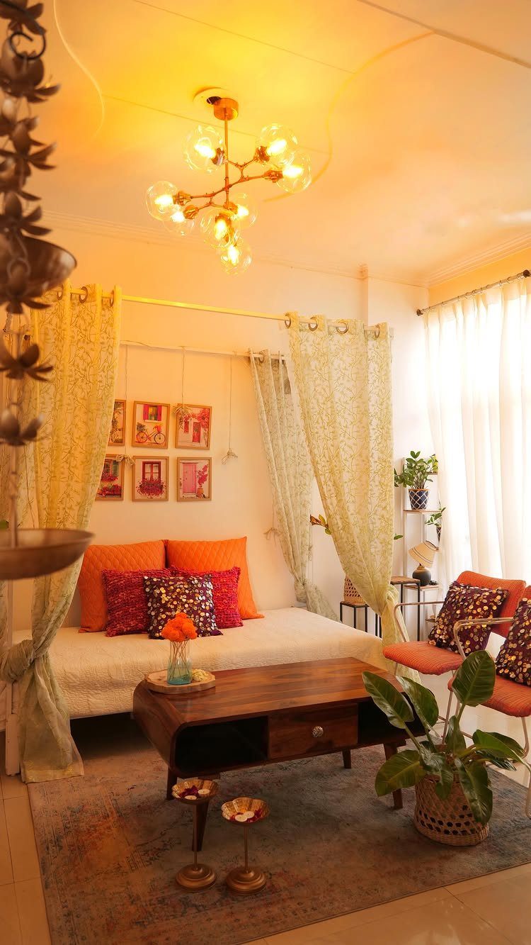 Bright orange and patterned purple cushions on a white daybed in a warm room.