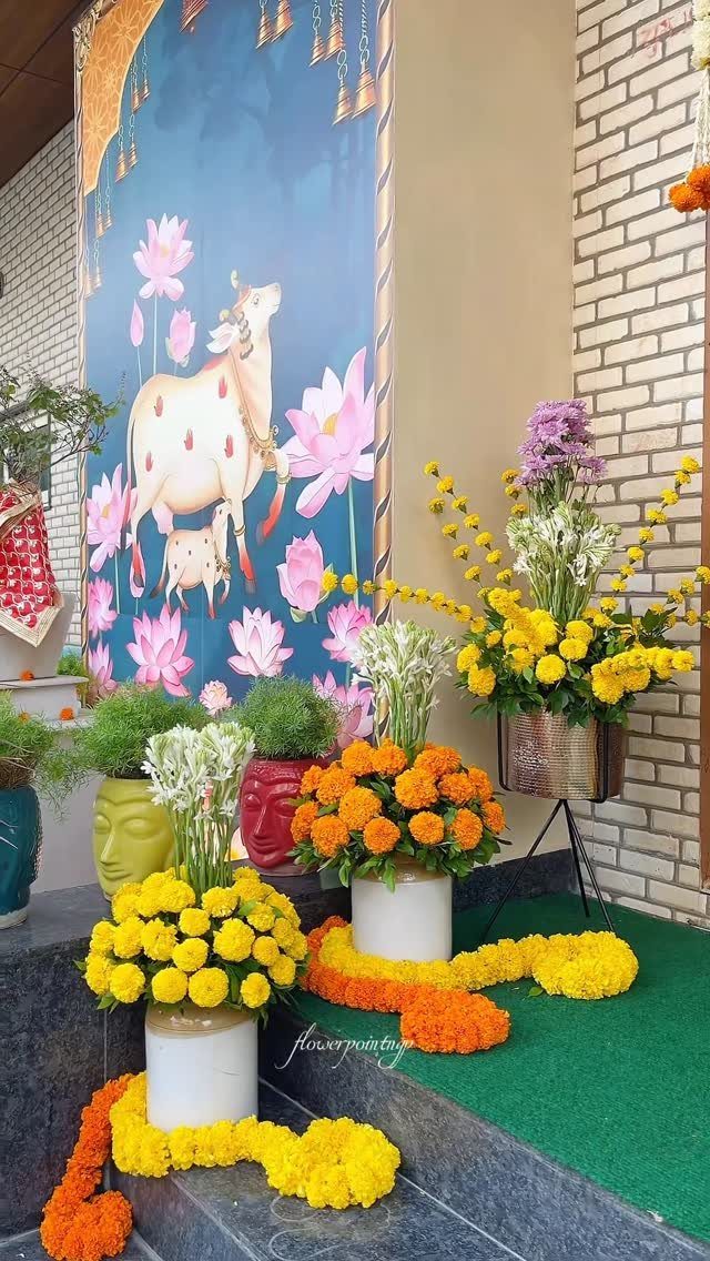 Yellow and orange marigolds in colorful vases arranged on a grey step.