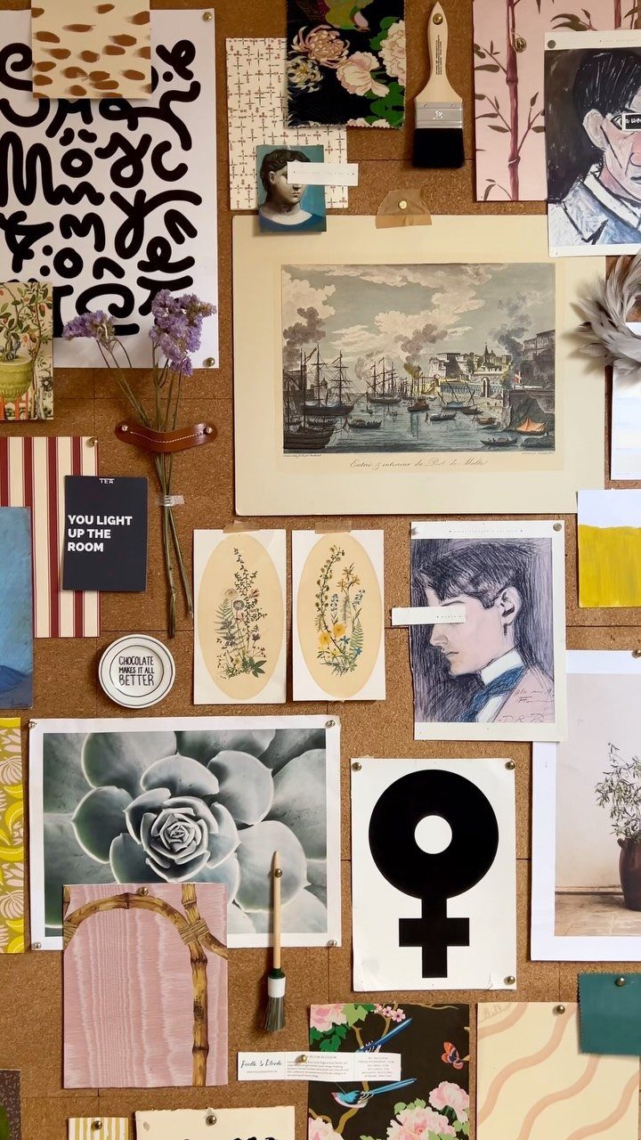 Cork pinboard decorated with artistic sketches, photographs, and dried purple flowers.
