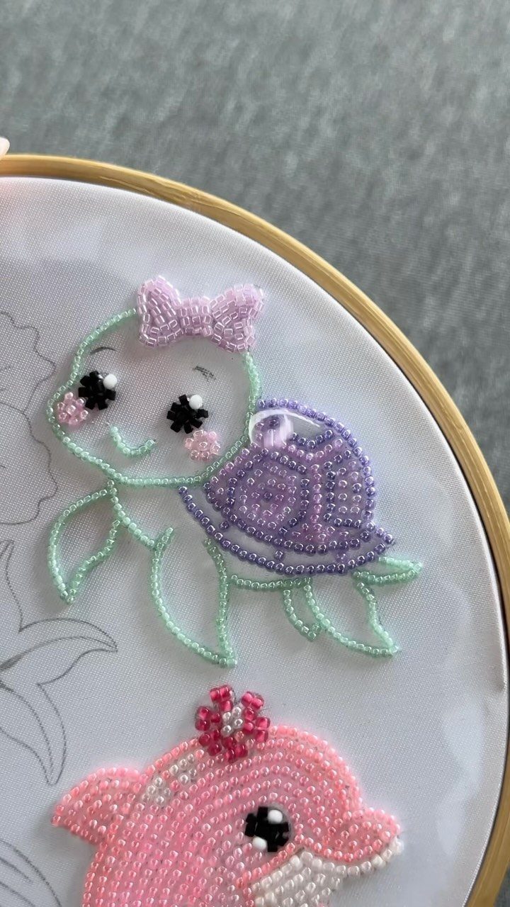 Beaded embroidery of a cute turtle and dolphin in a wooden hoop