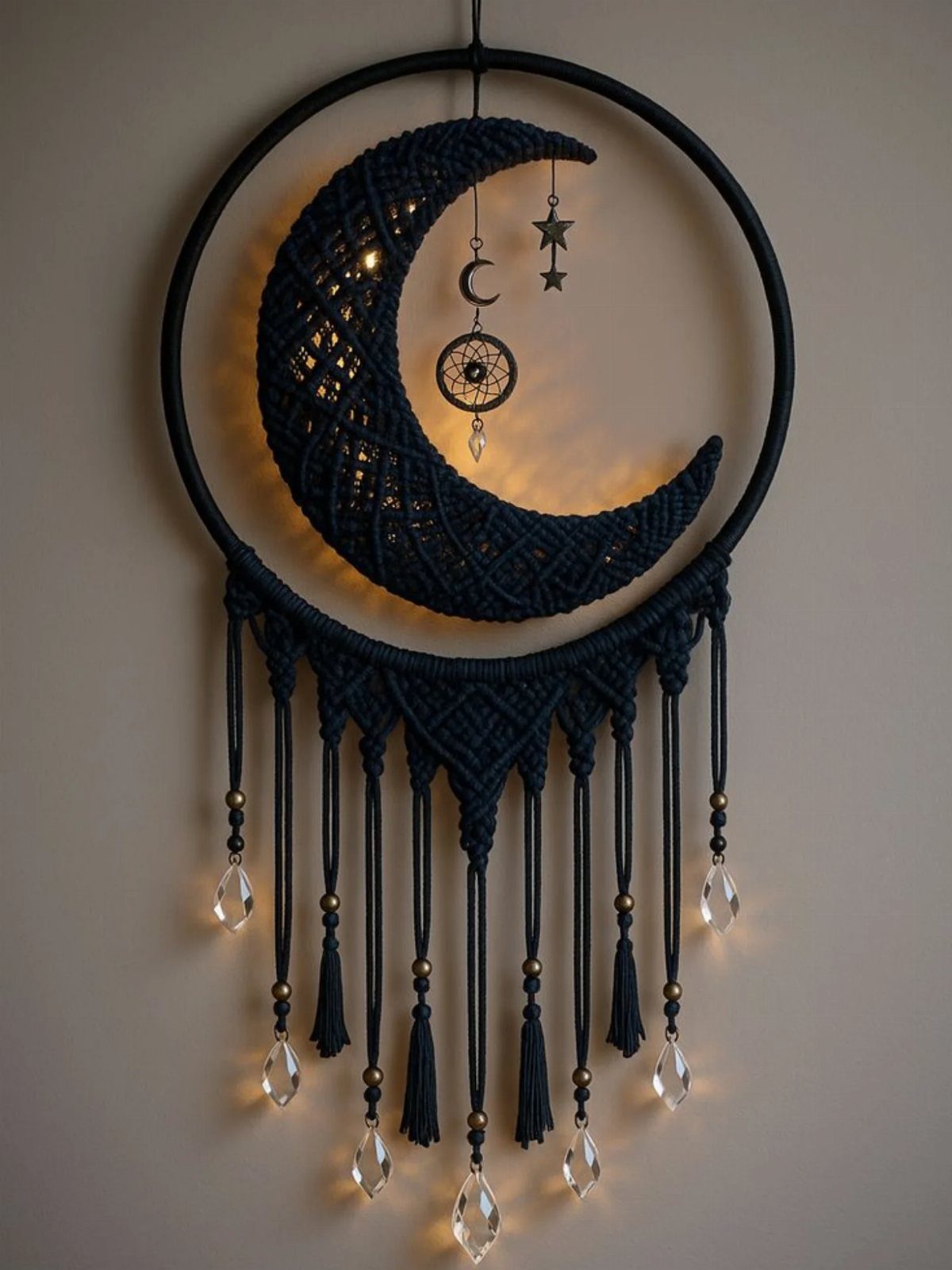 Black macramé wall hanging with a crescent moon and hanging crystal beads.