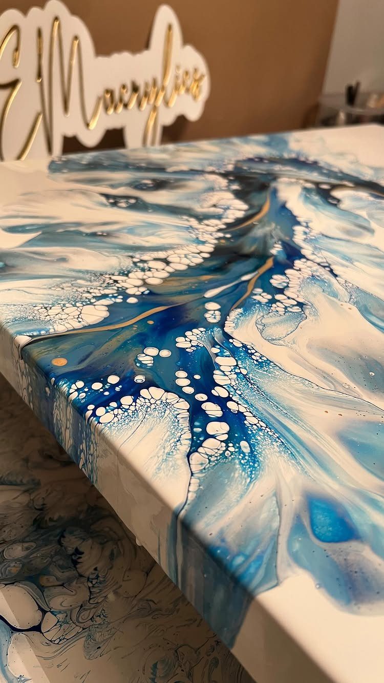 Resin art canvas with blue and white ocean wave patterns and gold accents.