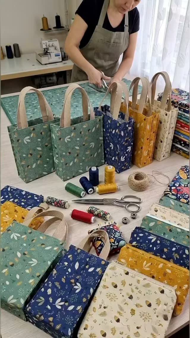Handmade fabric tote bags and sewing tools on a table with a seamstress.