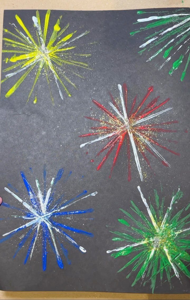 Colorful painted fireworks in red, blue, yellow, and green on black paper.