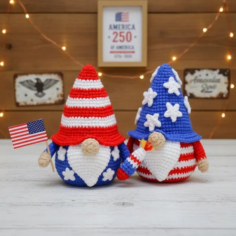 Two crocheted patriotic gnomes with red, white, and blue patterns and American accessories.