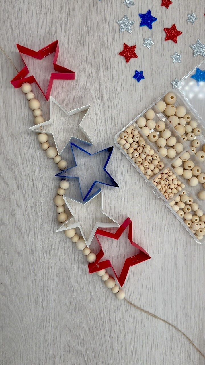 Patriotic garland with red, white, and blue stars and wooden beads on wood.