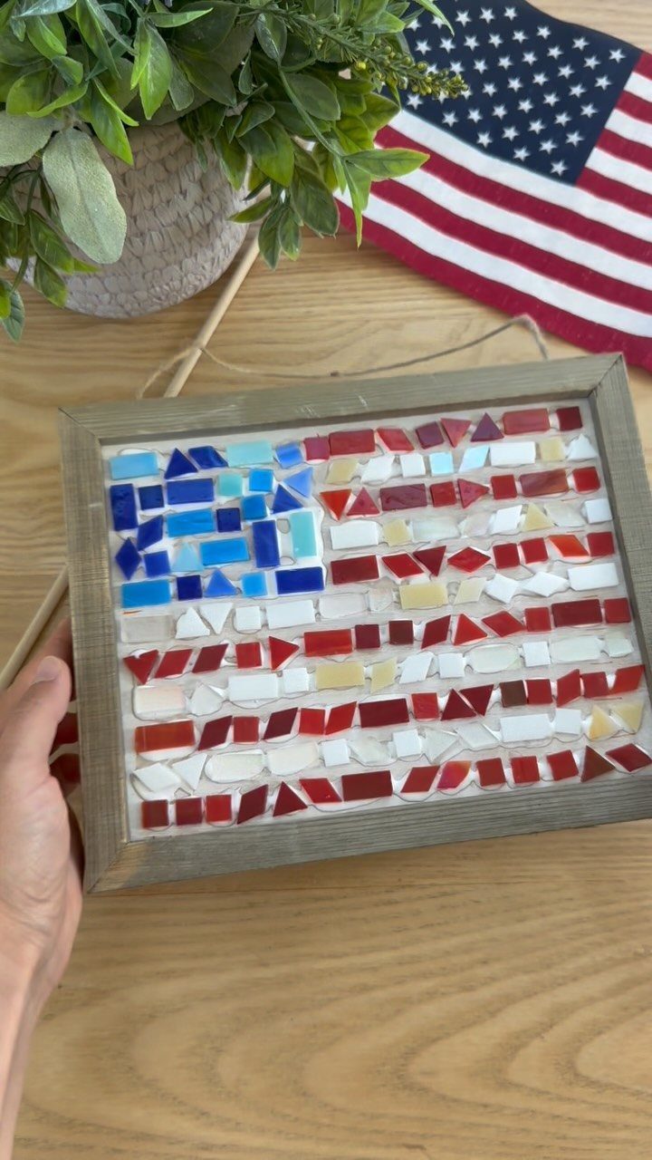 Mosaic American flag made of red, white, and blue tiles in wooden frame