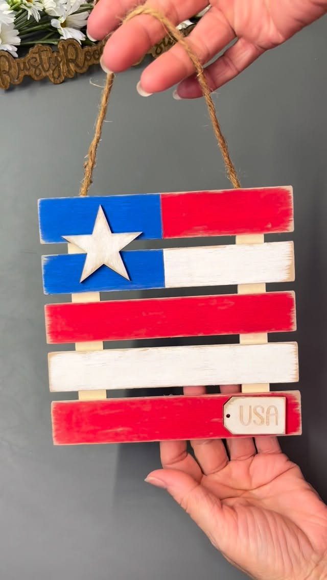 Handmade wooden USA flag sign with red, white, and blue paint and a star.