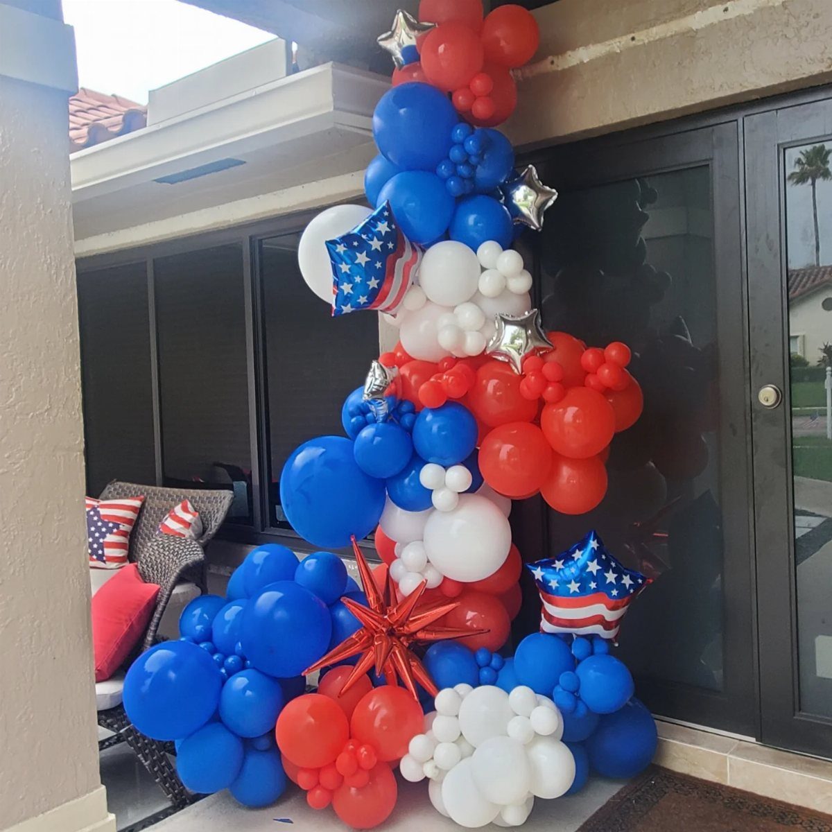 Red, white, and blue balloon arch with star accents for Fourth of July