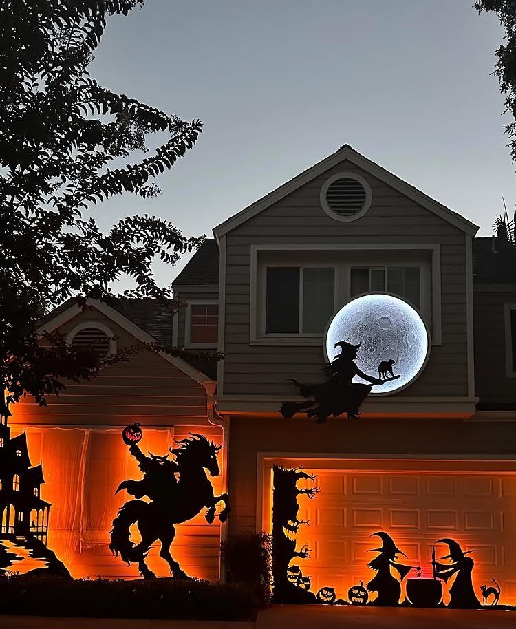 Halloween silhouettes of a headless horseman and witches on a house exterior