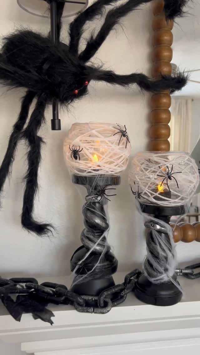 Two white spiderweb lanterns on black pedestals with a large black spider decoration.
