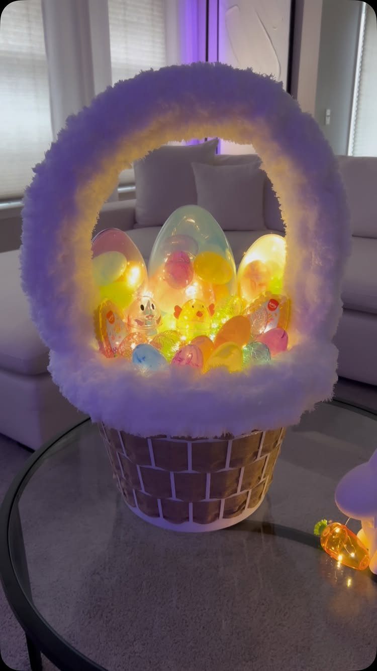 Glowing colorful Easter eggs and chicks inside a white fluffy basket on glass table