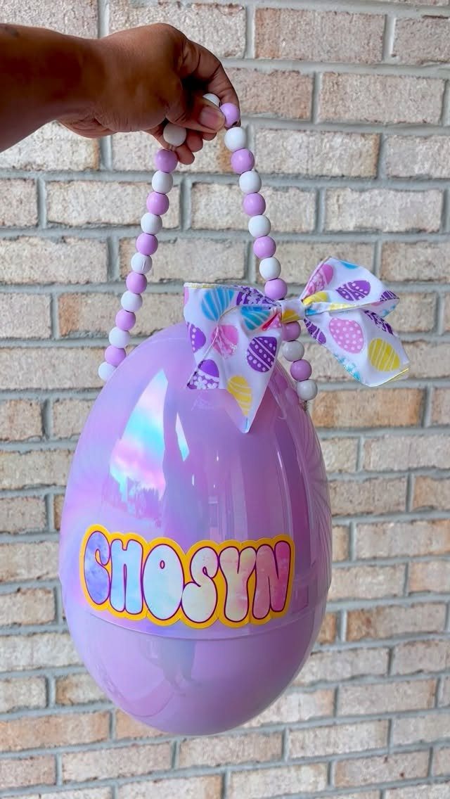 Iridescent purple plastic Easter egg basket with beaded handle and colorful name decal.