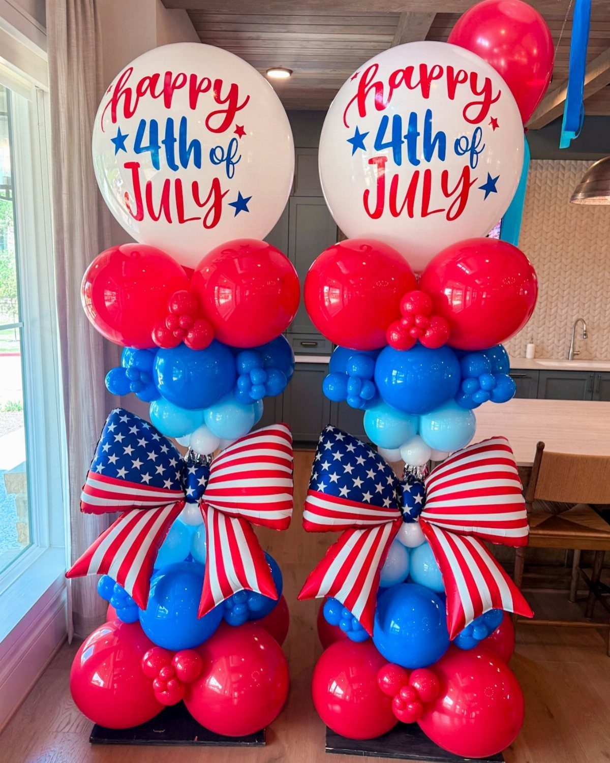 Two red, white, and blue balloon columns with festive Fourth of July text.