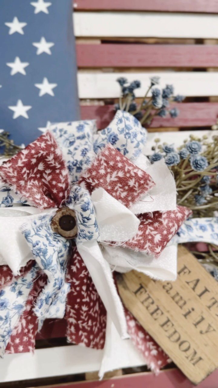 Fabric patriotic bow on a wooden American flag background with a freedom sign.