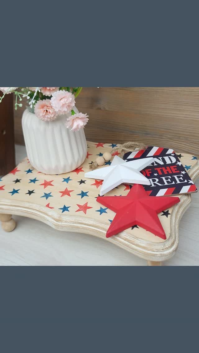 White wooden tray with red and blue stars holding patriotic star decorations