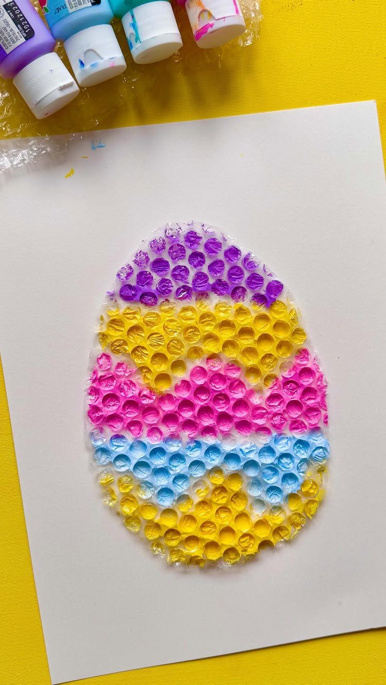 Colorful Easter egg painting made with bubble wrap texture on white paper.