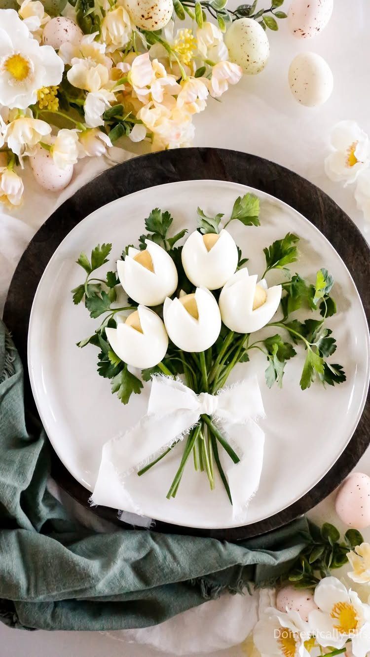 Hard-boiled eggs carved into tulip shapes arranged with parsley on a white plate.